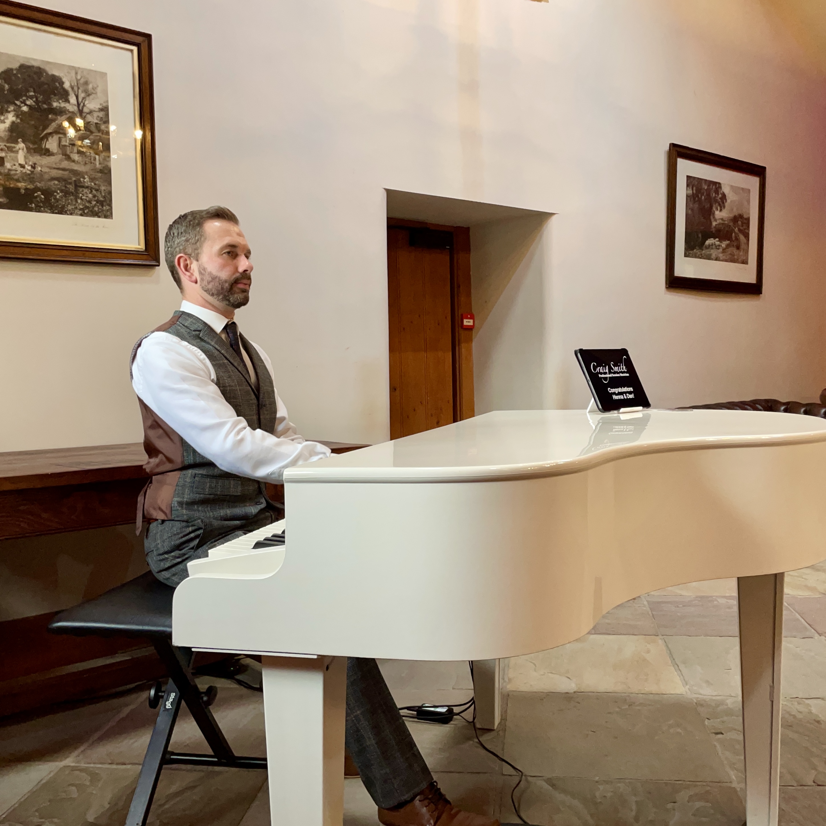 Wedding pianist Craig Smith performing on a white piano during a drinks reception at Browsholme Hall