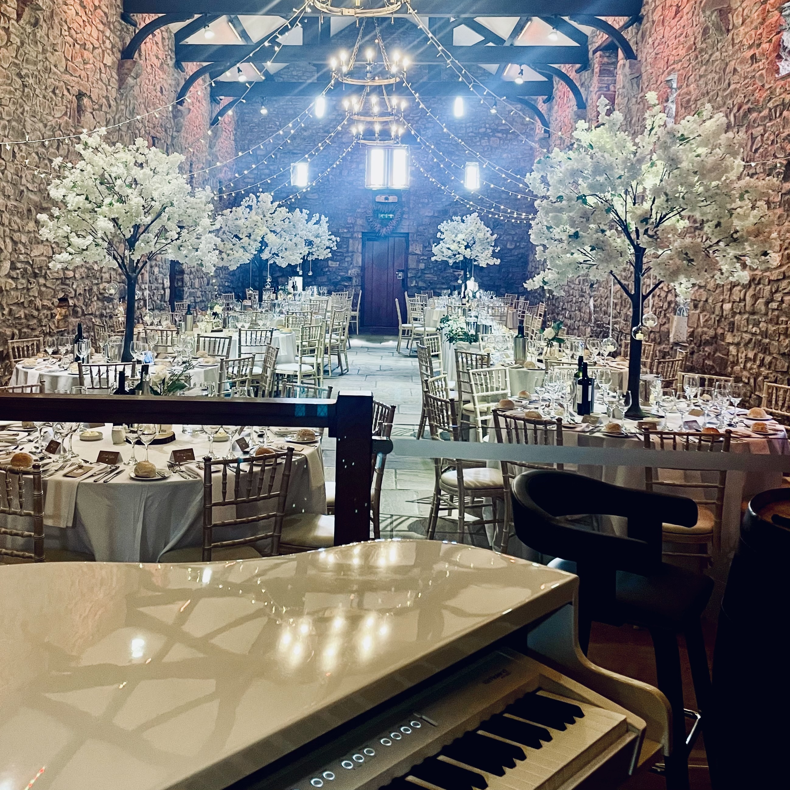 Wedding pianist Craig Smith's white piano set up ready for wedding breakfast at The Tithe Barn Browsholme Hall