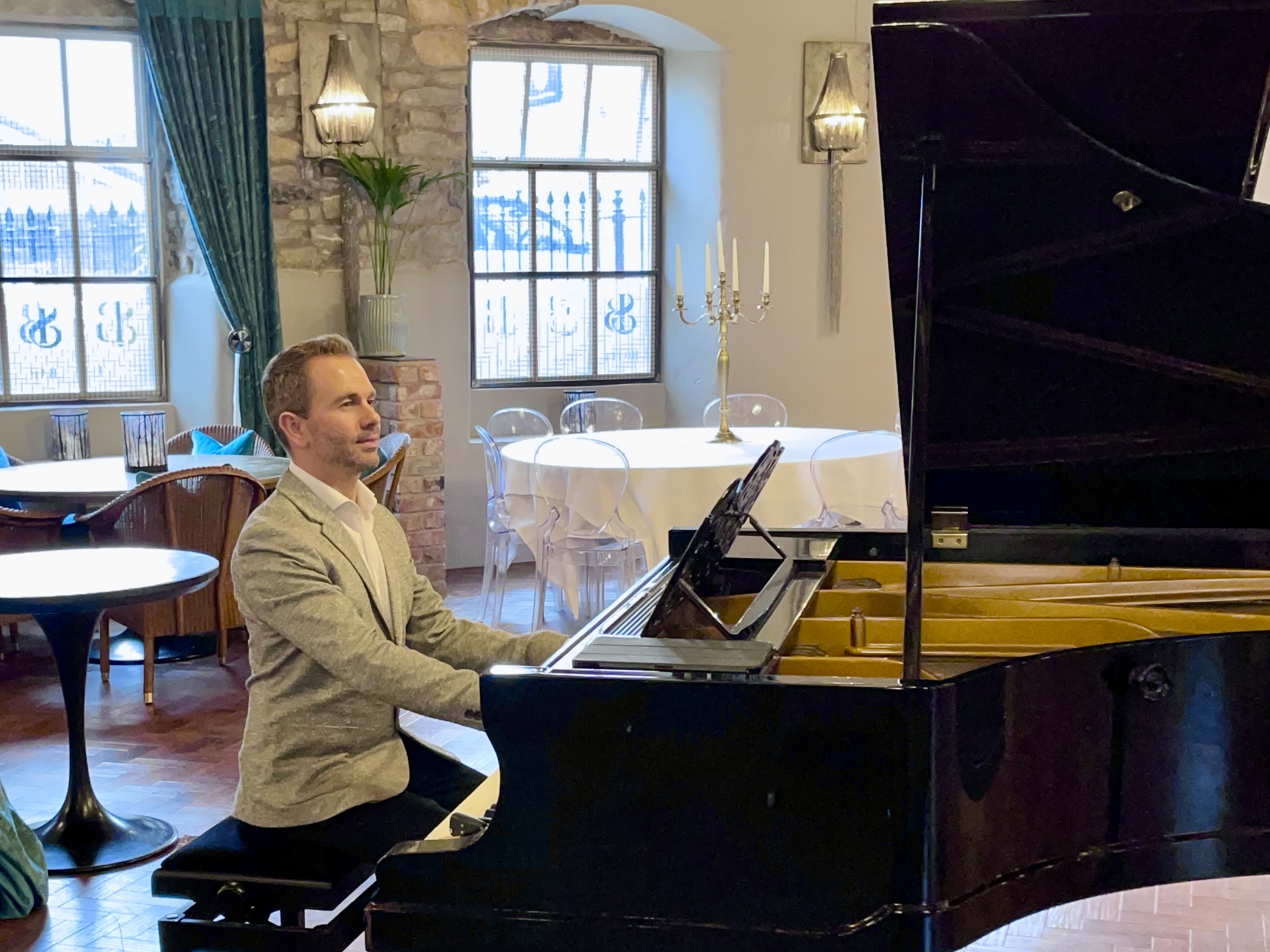 Holmes Mill wedding pianist Craig Smith playing grand piano in the Bistro during a wedding reception