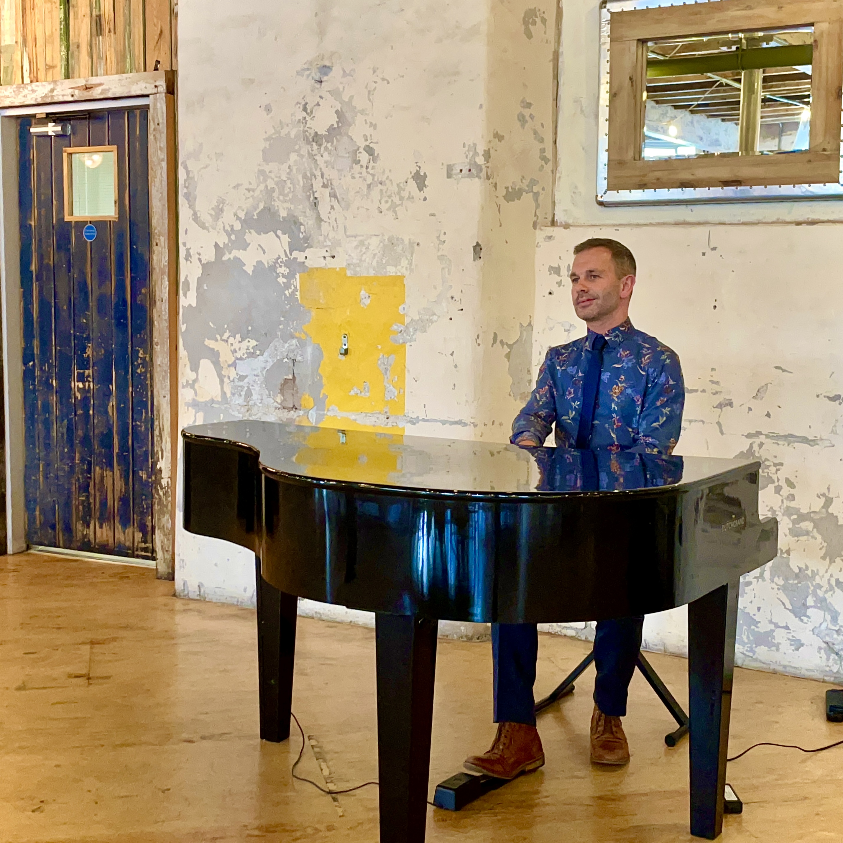 Wedding pianist Craig Smith plays his black baby grand piano during a wedding breakfast