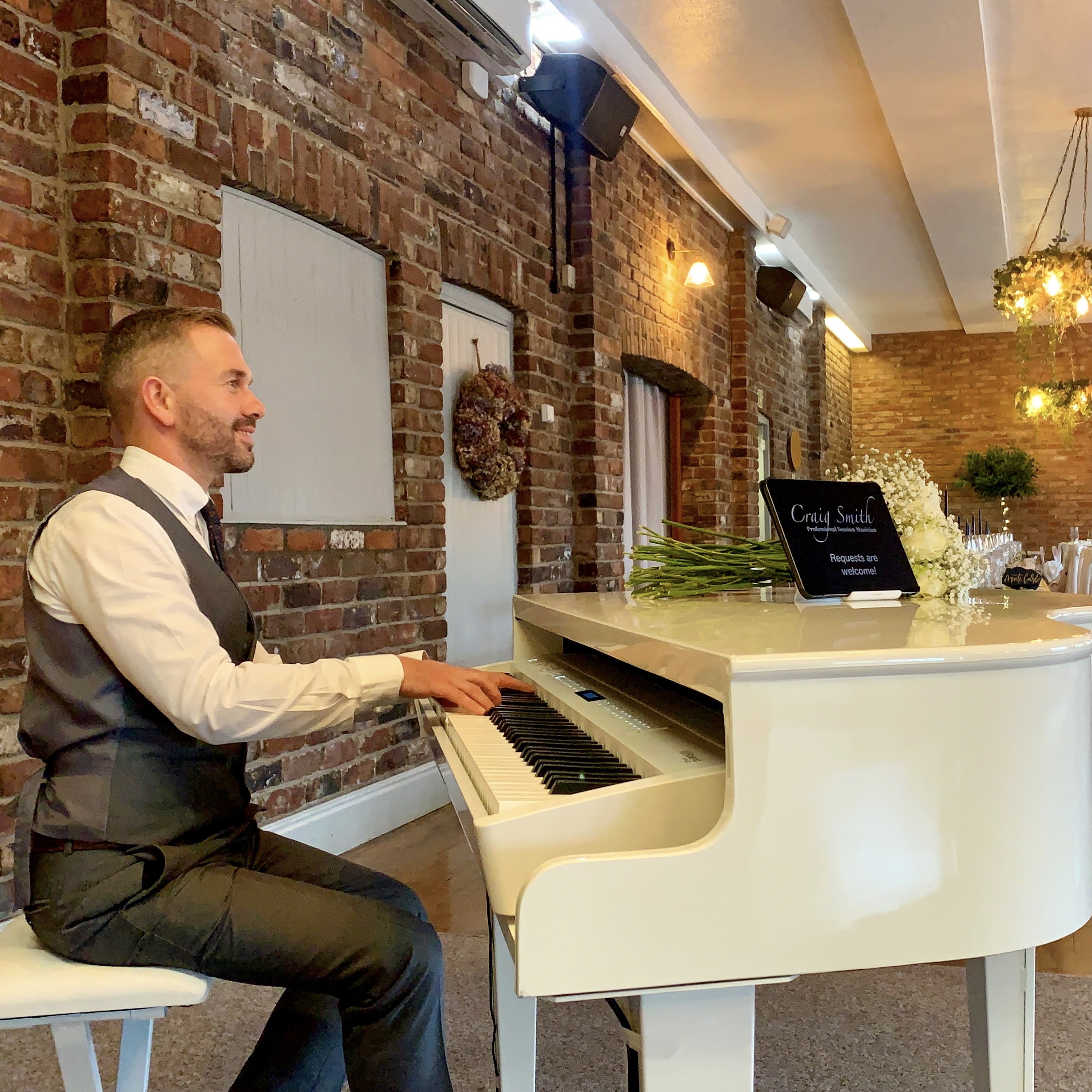 Wedding pianist Craig Smith plays at a Larkspur Lodge wedding breakfast on his white baby grand piano 