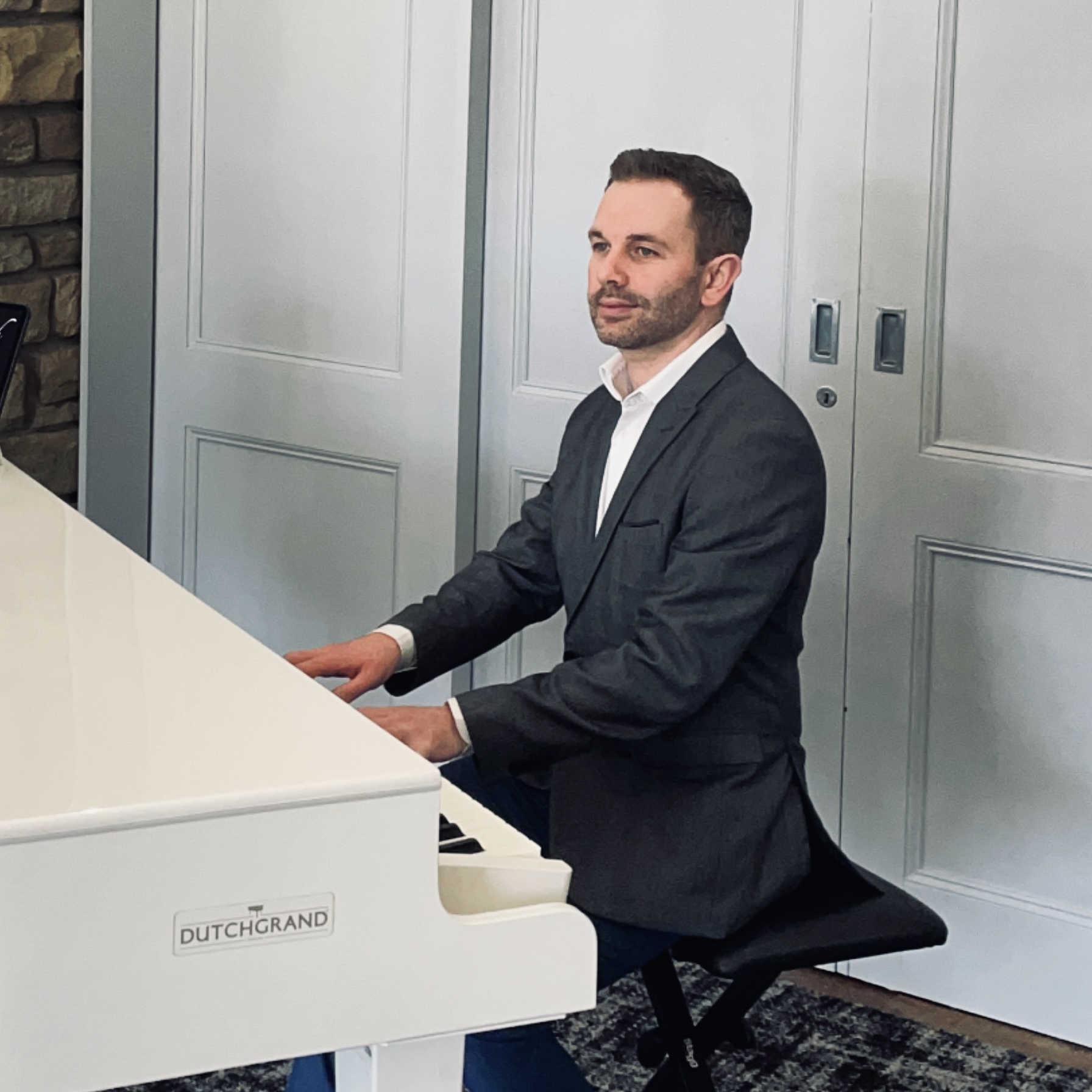 Mytton Fold wedding pianist Craig Smith performs on a white baby grand piano for a drinks reception