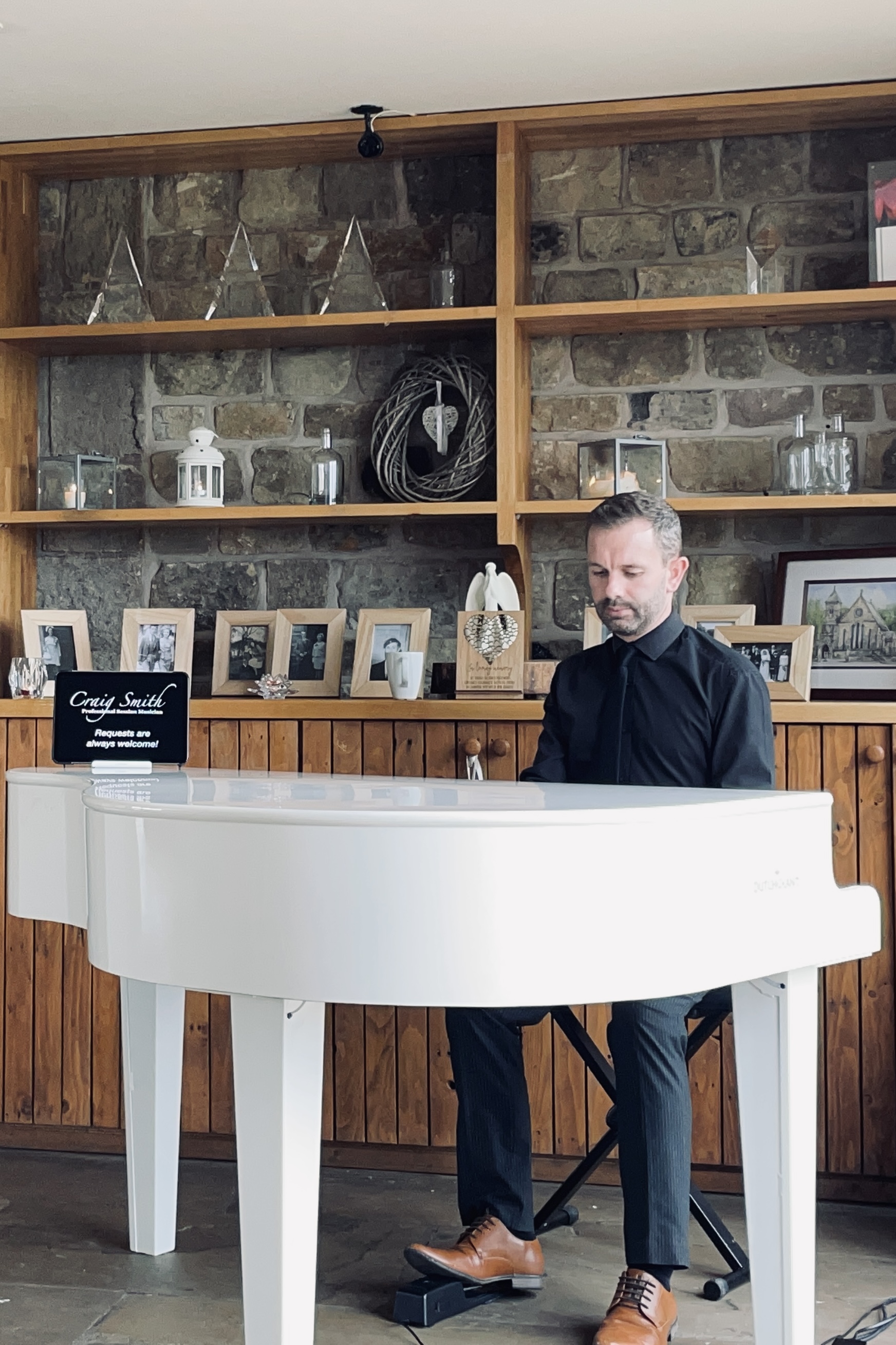 Craig Smith plays piano during a drinks reception at The Out Barn.