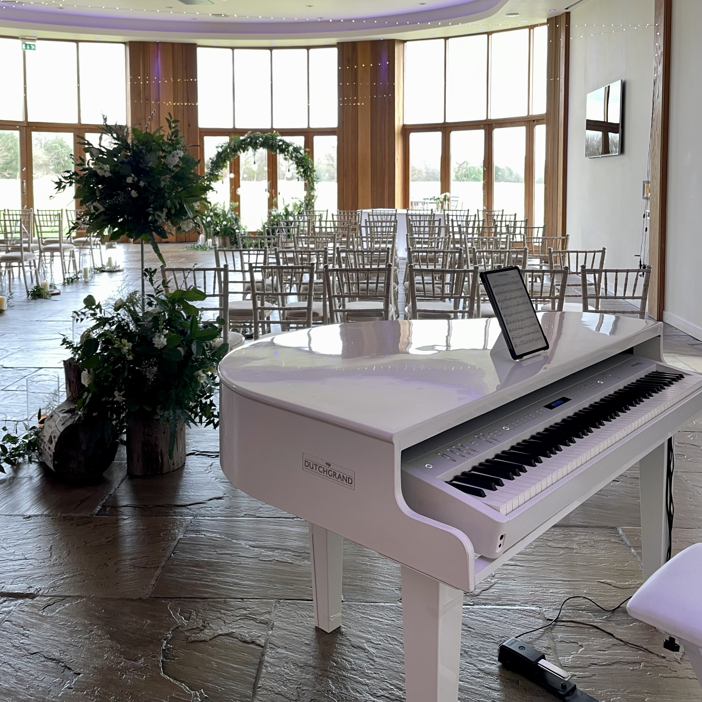 The Out Barn's wedding pianist Craig Smith's white piano set up ready for wedding ceremony
