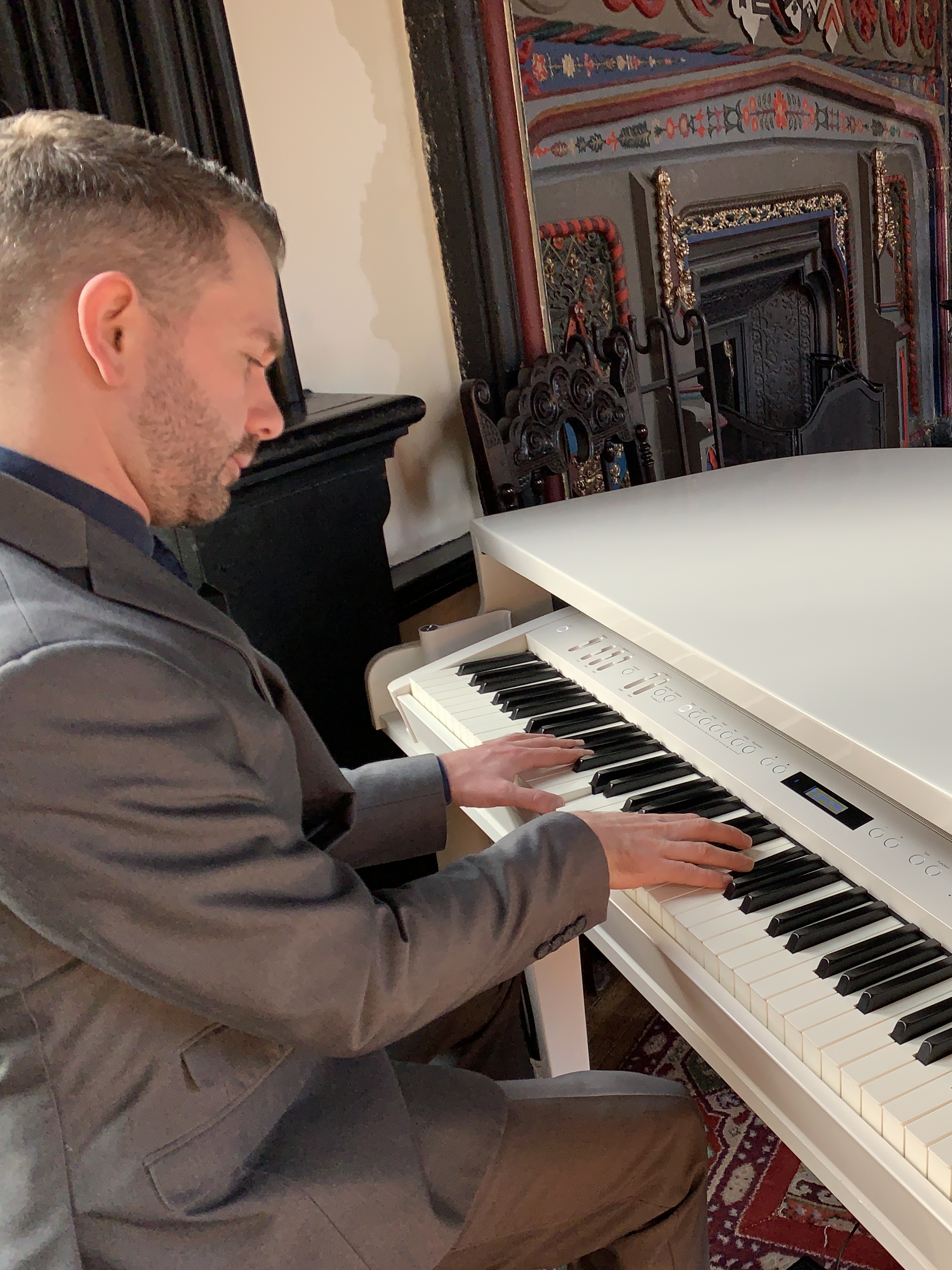 Craig Smith plays his white baby grand piano during a Samlesbury Hall wedding drinks reception