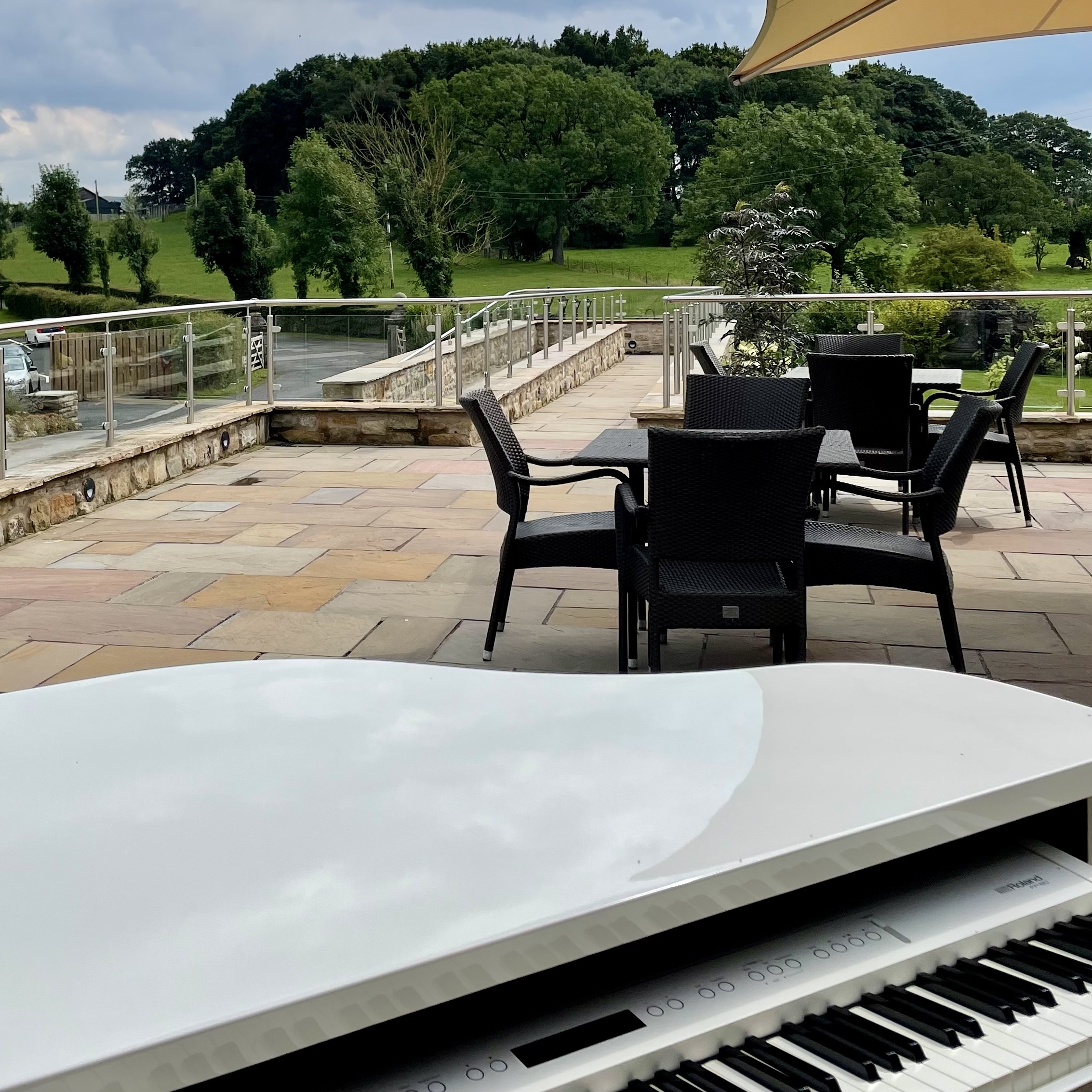 Wedding pianist Craig Smith's white piano ready for a Stirk House wedding reception out on the terrace
