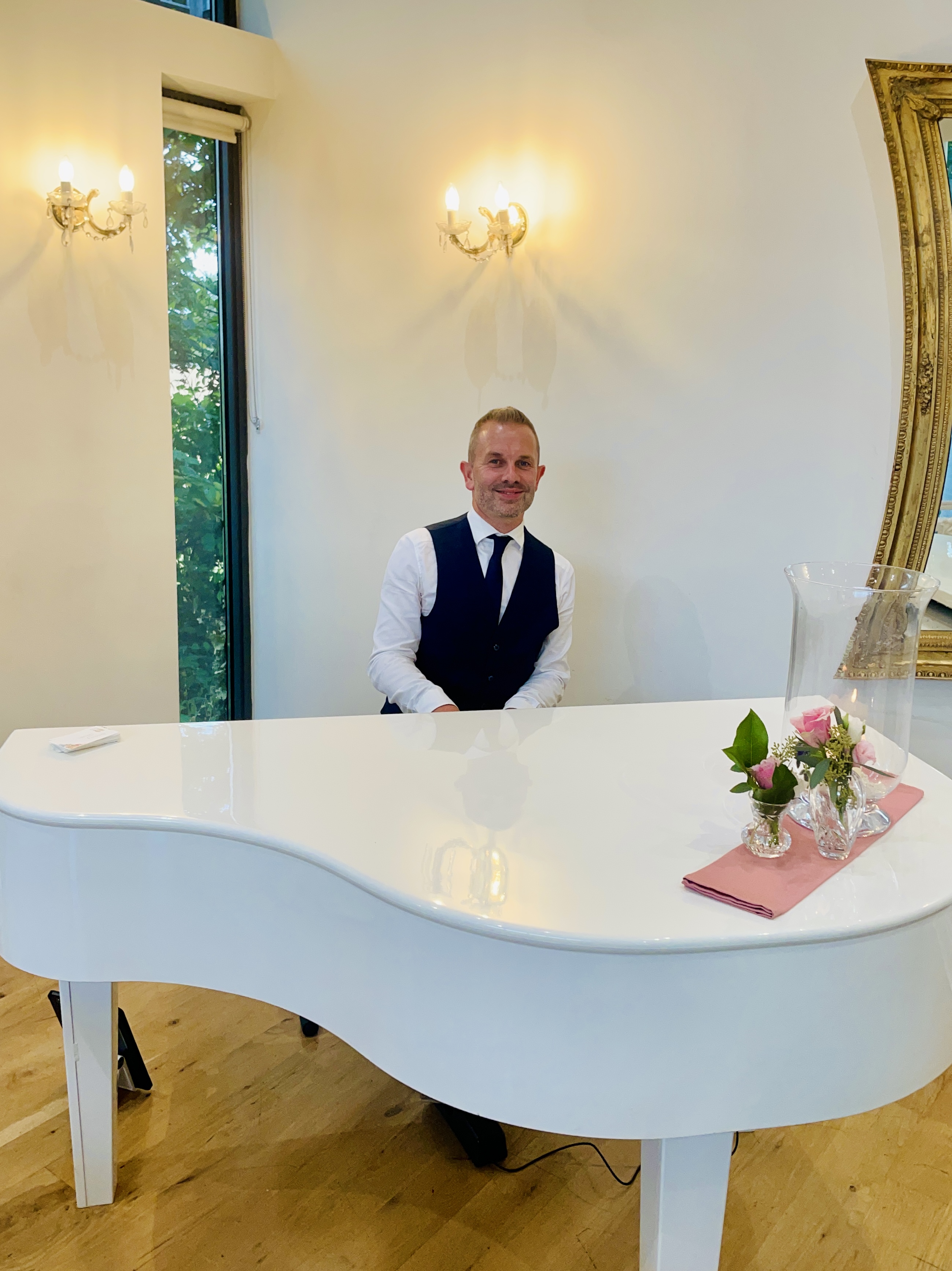West Tower's recommended wedding pianist Craig Smith smiles from the piano ahead of a ceremony in The Ballroom.